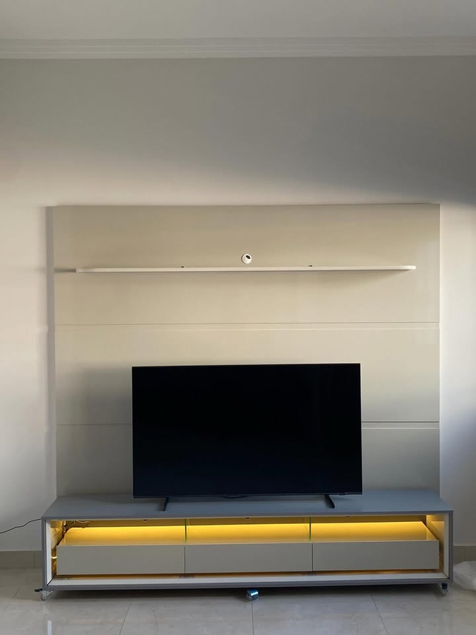Rack com iluminação embutida e painel claro para televisão